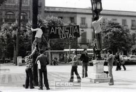 Jóvenes colgando el cartel &quot;Amnistía total&quot; en la plaza Nueva – Foto 1